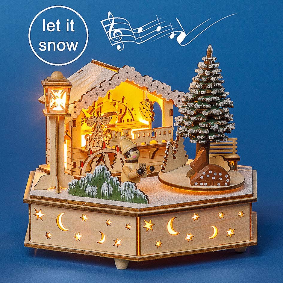 The Music Box: Christmas Shop in the Park – Lighted Music Box features a winter scene with a lit house, snow-covered tree, child figure, and stars. Musical notes and “let it snow” add festive charm to your holiday décor.
