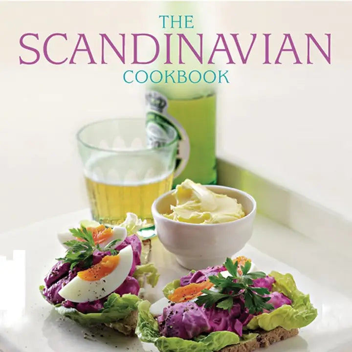 Cover of The Scandinavian Cookbook - Fresh and Fragrant Cooking features open sandwiches with eggs and vegetables, butter bowl, and beer glass, capturing the essence of Scandinavian cuisine. Ideal for those who enjoy authentic recipes.