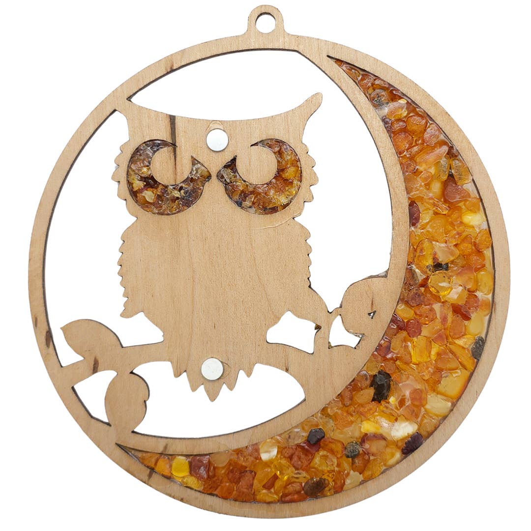 The Owl Amber Suncatcher/Magnet features a wooden owl silhouette gracefully perched on a crescent moon, decorated with Baltic amber stones.