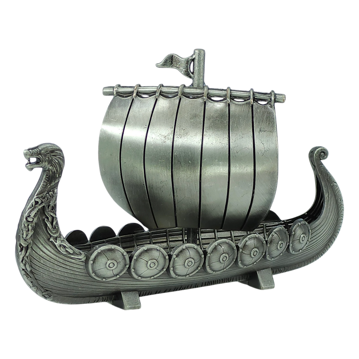 The Figurine: Norwegian Viking Ship with Sail Pewter 5″x3″ Table Decor by Faire - Scandinavian Specialties is a handcrafted keepsake that beautifully captures Scandinavian heritage, featuring a dragon-shaped prow, detailed shields along the side, and a single sail with a small flag atop—expertly crafted in pewter.