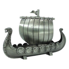 The Figurine: Norwegian Viking Ship with Sail Pewter 5″x3″ Table Decor by Faire - Scandinavian Specialties is a handcrafted keepsake that beautifully captures Scandinavian heritage, featuring a dragon-shaped prow, detailed shields along the side, and a single sail with a small flag atop—expertly crafted in pewter.