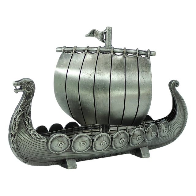 The Figurine: Norwegian Viking Ship with Sail Pewter 5″x3″ Table Decor by Faire - Scandinavian Specialties is a handcrafted keepsake that beautifully captures Scandinavian heritage, featuring a dragon-shaped prow, detailed shields along the side, and a single sail with a small flag atop—expertly crafted in pewter.