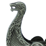 A close-up of the “Norwegian Viking Ship with Sail Pewter 5′‘x3’’ Table Decor” by Faire - Scandinavian Specialties, showcasing the figurine’s intricately detailed metallic dragon head prow adorned with knotwork patterns inspired by traditional Norwegian craftsmanship.