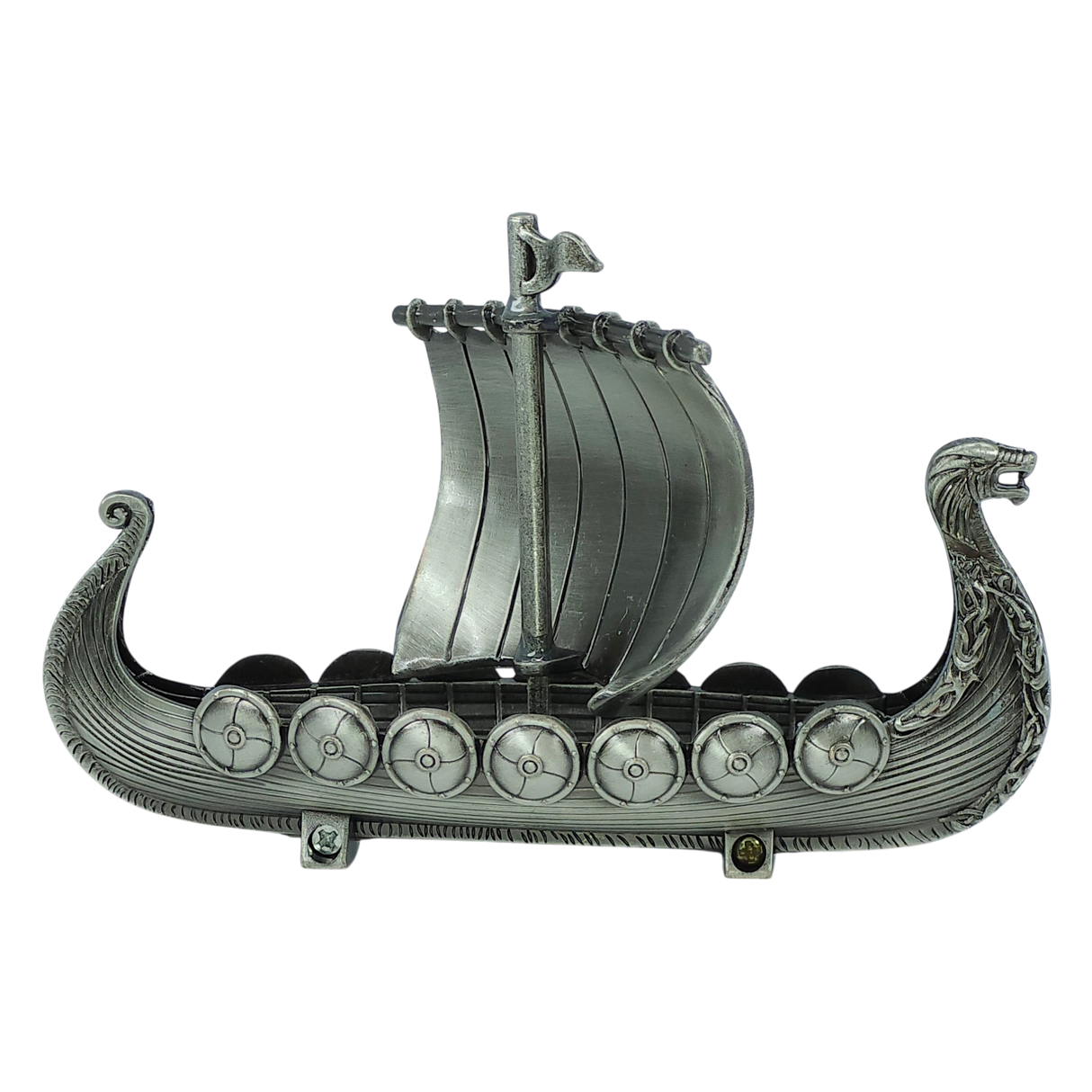 Handcrafted by Faire - Scandinavian Specialties, the Norwegian Viking Ship with Sail Pewter Figurine (5″x3″) features a silver-gray finish, a dragon-headed prow, decorated shields along the sides, and a single raised sail at the center. Intricate carvings embellish both the sides and prow, evoking the spirit of a classic Viking longship—making it an ideal table decor keepsake.