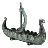 The Figurine: Norwegian Viking Ship with Sail Pewter 5″x3″ Table Decor by Faire - Scandinavian Specialties is a meticulously handcrafted metallic model featuring a dragon-shaped prow, single mast, and intricately detailed shields along the sides—a striking Norwegian keepsake perfect for collectors and history enthusiasts.