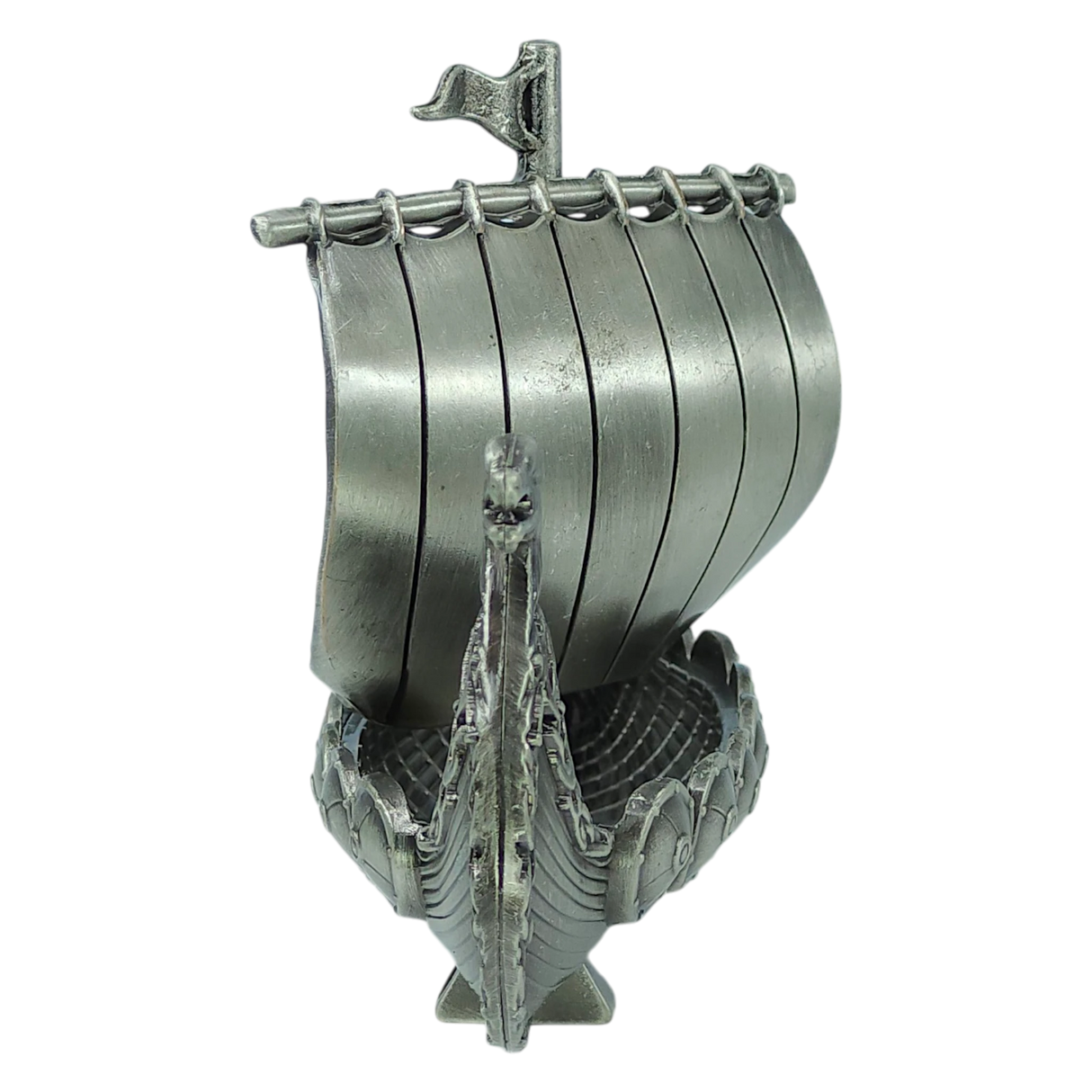 A handcrafted pewter Norwegian Viking ship figurine by Faire - Scandinavian Specialties, featuring a curved hull, decorated prow, and vertical slats forming the sail—this 5″x3″ table decor piece is a front-view keepsake reminiscent of a traditional longship.