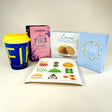 The Fika Starter Pack includes a yellow and blue travel mug, Löfbergs Dark Roast coffee, ginger snaps, a book, and a dessert-illustrated napkin—everything you need for an authentic Swedish coffee break.