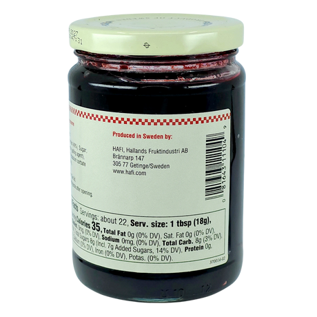 Glass jar with a white lid containing Swedish blueberry preserves, back facing forward to show the nutrition label and producer information.
