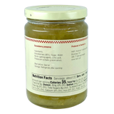 Glass jar of green, chunky gooseberry preserves with a white label displaying ingredients, nutrition facts, and storage instructions.