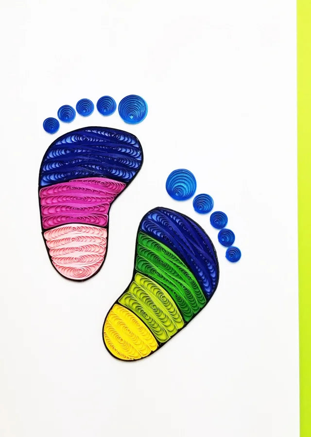 The Baby Footprint Quilling Card is a stunning handcrafted card displaying finely quilled paper artwork of two colorful baby footprints on a pristine white background, made with high-quality paper.