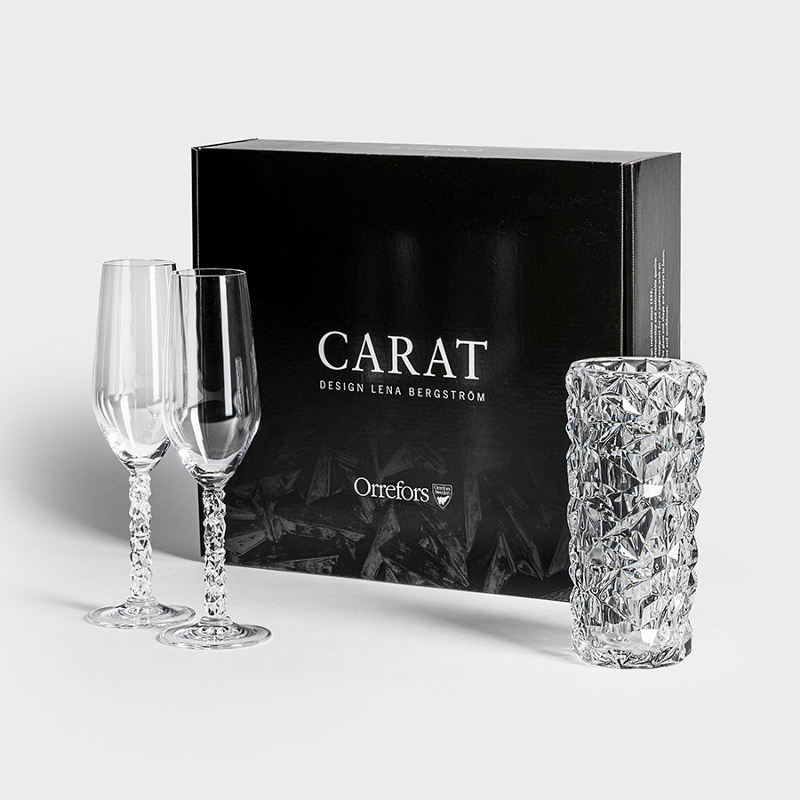 The Orrefors Carat 3 Piece Gift Set, designed by Lena Bergström, showcases two elegant crystal flute glasses and a textured tumbler.