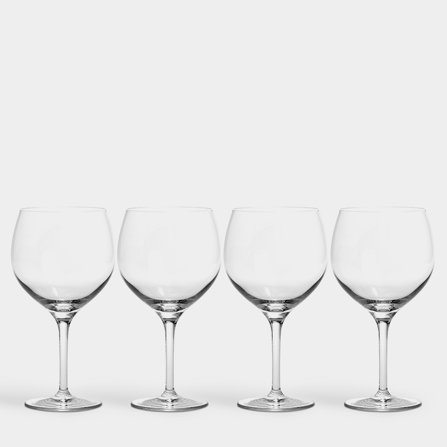 The Orrefors Gin and Tonic Glasses 22oz (4-Pack), elegantly aligned on a white background, evoke a sense of sophistication reminiscent of Barcelonas vibrant drinking culture.