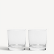 A pair of clear, empty KostaBoda Limelight Double Old Fashioned 15oz glasses are displayed on a white background.