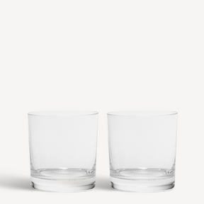 A pair of clear, empty KostaBoda Limelight Double Old Fashioned 15oz glasses are displayed on a white background.