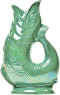 Certainly! Here’s a rewritten version of the sentence using the provided product data: The Original Gluggle Jug Factory presents the Gluggle Jug Lustre, a green ceramic fish-shaped pitcher made in Europe. Featuring textured scales, an open mouth spout, and a curved tail handle, this whimsical jug is renowned for its signature gurgling sound when pouring—combining playful design with everyday practicality.