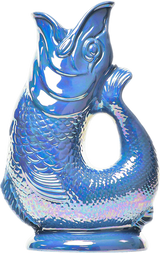 The Gluggle Jug: Gluggle Jug Lustre Made in Europe is a shiny blue, fish-shaped pitcher with textured scales, an open mouth, and a lustre glaze, designed to stand upright on a flat base.