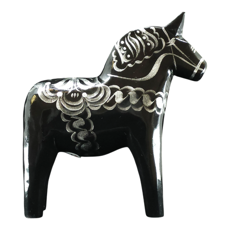 The Dala Horse: Black & Silver "Celebrate Series" by Grannas Olsson is a 13 cm handcrafted Swedish figurine, featuring silver patterns on black wood and inspired by traditional folk art.
