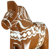 A close-up of the Grannas Olsson Dala Horse: Brown Swedish Dala Horse "Gingerbread" (13 cm), handcrafted in Sweden and adorned with intricate white patterns, is set against a plain white background.