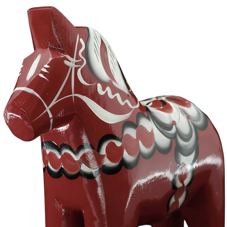 Close-up of the Grannas Olsson Dala Horse: Burgundy "Maria / Anniversary Series" (15 cm), handcrafted in Sweden with white, black, and gray patterns, set against a white background.