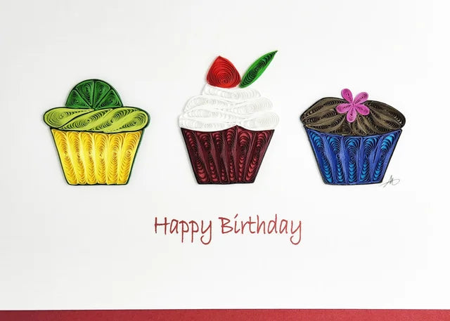 The Happy Birthday Cupcake Card showcases three handcrafted quilled paper cupcakes in green, red, and blue set against a pristine white background with Happy Birthday elegantly written below.