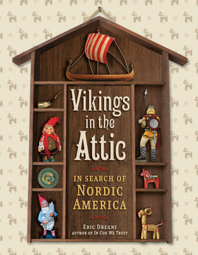 Book cover for Vikings in the Attic In Search of Nordic America by Eric Dregni (Paperback), featuring a Viking ship and figurines in a wooden case that evoke Scandinavian-American heritage.