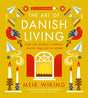 Book cover titled The Art of Danish Living by Meik Wiking features illustrations of candles, birds, and a sunburst. Subtext: Discover how the happiest people find joy at work and balance in life through Danish living.