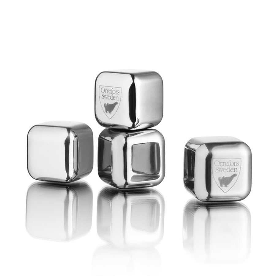 The Orrefors: City Ice Cubes (4-Pack) features four elegant metal cubes, three stacked and one beside, engraved with Orrefors Sweden. Their polished stainless steel surfaces reflect light beautifully.