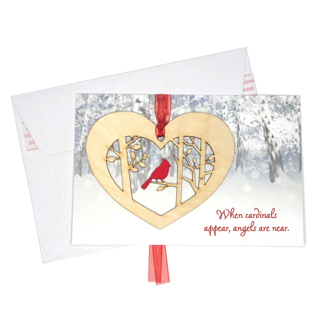 Heartfelt card featuring a hand-painted cardinal among wintry trees, complete with a heart-shaped cutout and the touching message: "When cardinals appear, angels are near." This beautiful piece is perfect for enhancing your holiday décor and celebrations.