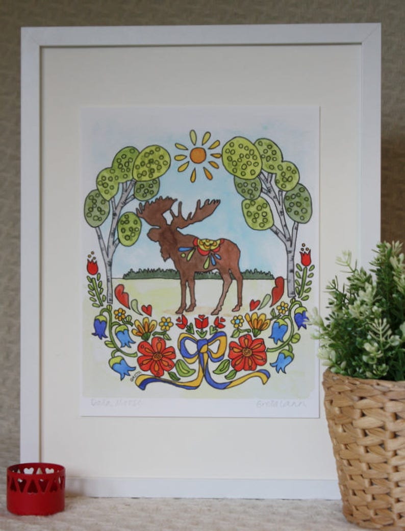 The "Dala Moose" by Greta Lann is an 11x14 print showcasing a moose among trees and flowers with Swedish folk art borders and a potted plant on the right.