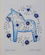 The artwork Blue Horse Blue Fluted by Greta Lann depicts a blue Dala Horse adorned with intricate blue and black floral patterns, surrounded by elegant floral swirls on a white background.