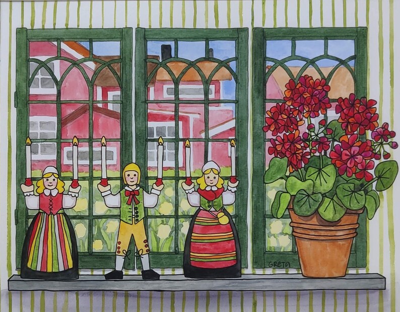 Three figurines in traditional dress holding candles stand on a windowsill beside a red geranium, with houses and greenery beyond—a charming scene captured in the artwork "Leksand Window" by Swedish artist Greta Lann.