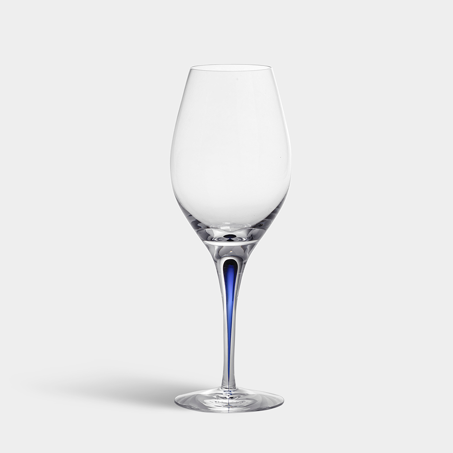 The Orrefors Intermezzo Blue Wine Balance Glass 14oz features a tall, slender stem and a subtle blue tint at the base, set against a plain gray background.