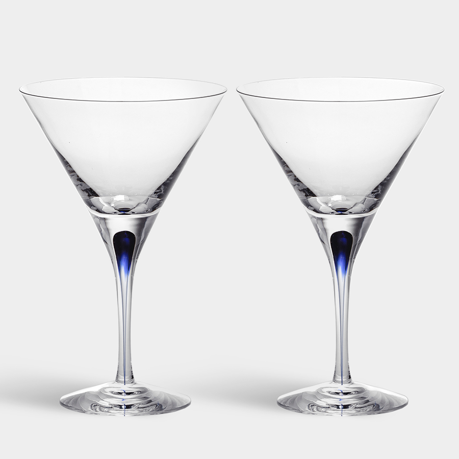 Two stylish Orrefors: Intermezzo Blue Martini Glasses, each with blue accents by designer Erika Lagerbielke, are set against a simple backdrop.