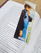 An open book with the Carl Larsson “Karin by the Shore” bookmark (8.5" × 2.5”), capturing Scandinavian countryside charm and artful detail—a nod to Nordic heritage for your reading moments. Labeled NORDIC 600°.