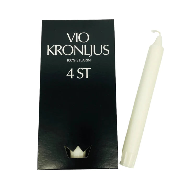 A Vio Kronljus White 4pc box sits beside one candle, labeled 100% stearin. Embrace Scandinavian tradition with this elegant set.