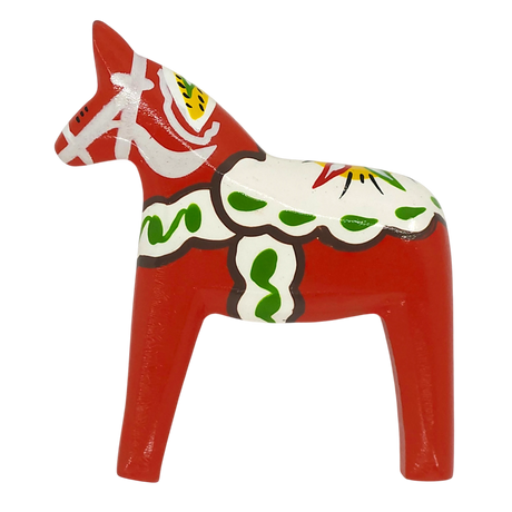 A red Dala Horse magnet with white, green, yellow, and black decorative patterns stands on all four legs against a plain white background.