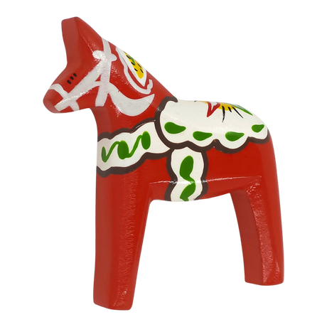 A red wooden Dala horse magnet with white, green, and yellow decorative patterns displayed on a plain white background.