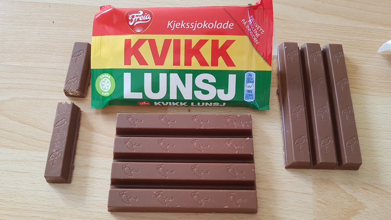 Freia Kvikk Lunsj Norwegian chocolate wafer bars (47g), branded as Quick Lunch, are attractively displayed on a wooden surface alongside their colorful packaging.