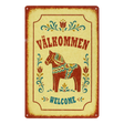 Swedish metal welcome sign displaying “Välkommen” and “Welcome,” with a central painted Dala horse and surrounding floral designs.