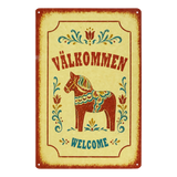 Swedish metal welcome sign displaying “Välkommen” and “Welcome,” with a central painted Dala horse and surrounding floral designs.