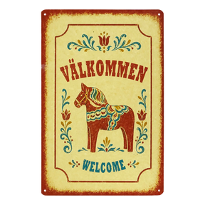 Swedish metal welcome sign displaying “Välkommen” and “Welcome,” with a central painted Dala horse and surrounding floral designs.