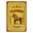Rectangular metal sign featuring a Dala horse, floral rosemaling patterns, and the text VÄLKOMMEN and WELCOME.