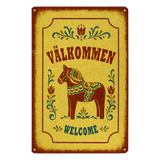 Rectangular metal sign featuring a Dala horse, floral rosemaling patterns, and the text VÄLKOMMEN and WELCOME.