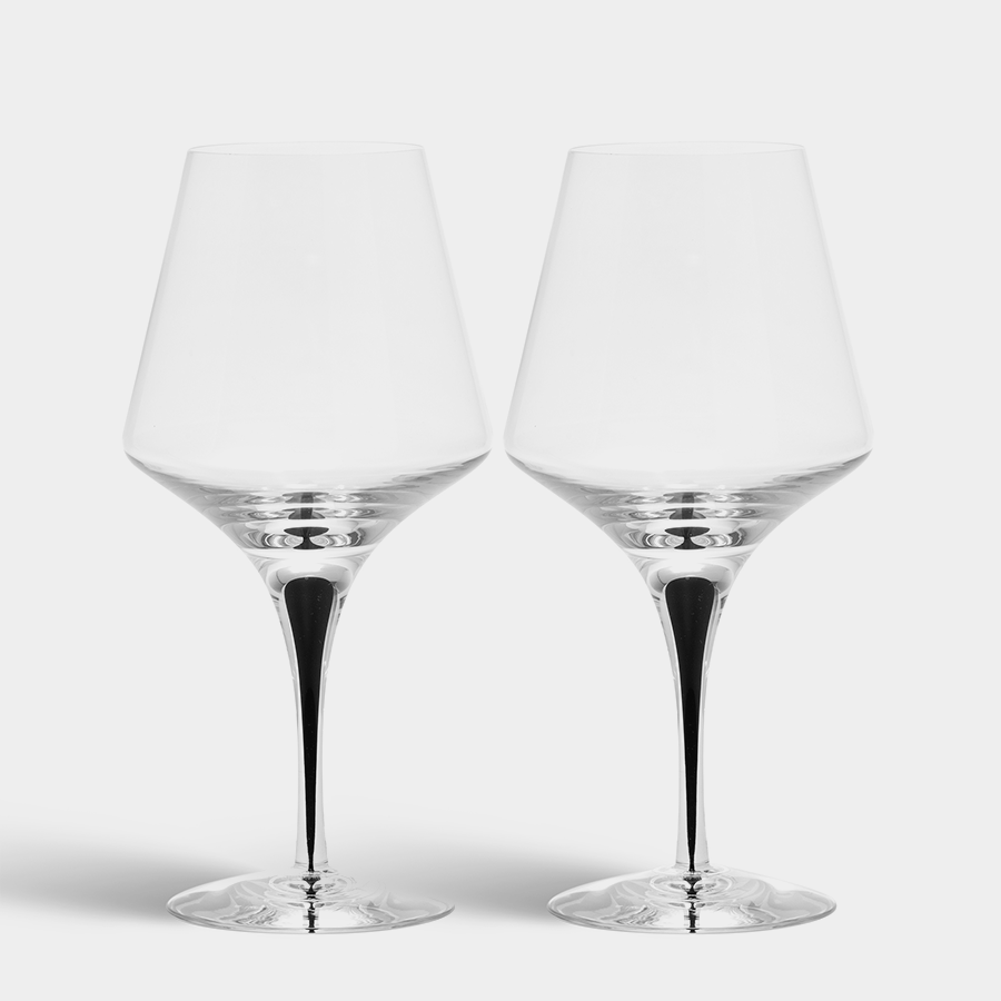 Two empty, mouth-blown Orrefors Metropol Red Wine Glasses (20.5oz, 2-Pack) with long stems rest elegantly side by side against a plain white background, reminiscent of Erika Lagerbielkes exquisite design for red wine glass enthusiasts.