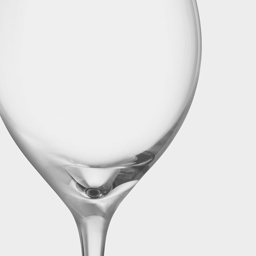 Close-up of an Orrefors: More Champagne Boule Glass, from a 4-pack, elegantly positioned upright against a plain white background with its thin stem, designed by Erika Lagerbielke.