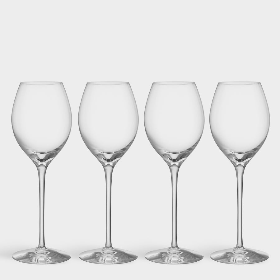 Four clear, empty wine glasses lined up evoke the elegance of Orrefors design, inspired by Erika Lagerbielkes mastery in crafting the More Champagne Boule Glass (4-Pack).