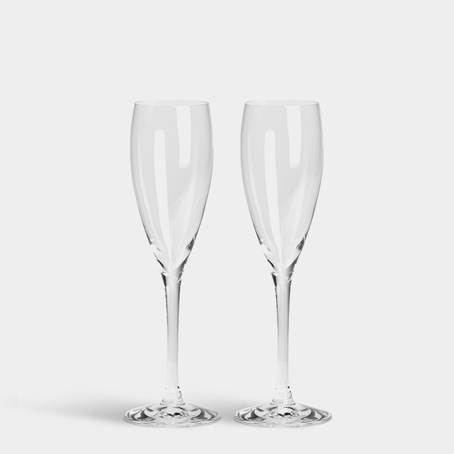 Two Orrefors: More Champagne Glass 5oz flutes gleam against a pristine white background, their crystal catching the light beautifully.