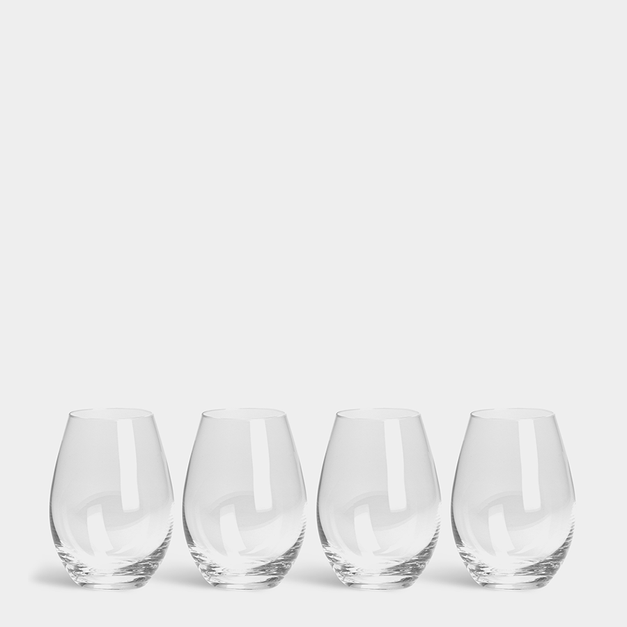 A set of four Orrefors: More Tumbler Glass 13oz glasses are lined up against a plain white background, showcasing their elegant simplicity and sophistication.