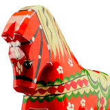 Close-up of the handcrafted Red Swedish Dala Horse "Färnäshästen" by Nils Olsson (14 cm), painted with white, green, yellow, and black patterns—an iconic piece of Swedish folk art—shown against a plain white background.