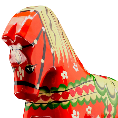 Close-up of the handcrafted Red Swedish Dala Horse "Färnäshästen" by Nils Olsson (14 cm), painted with white, green, yellow, and black patterns—an iconic piece of Swedish folk art—shown against a plain white background.
